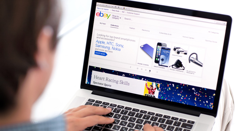 man browsing ebay on macbook