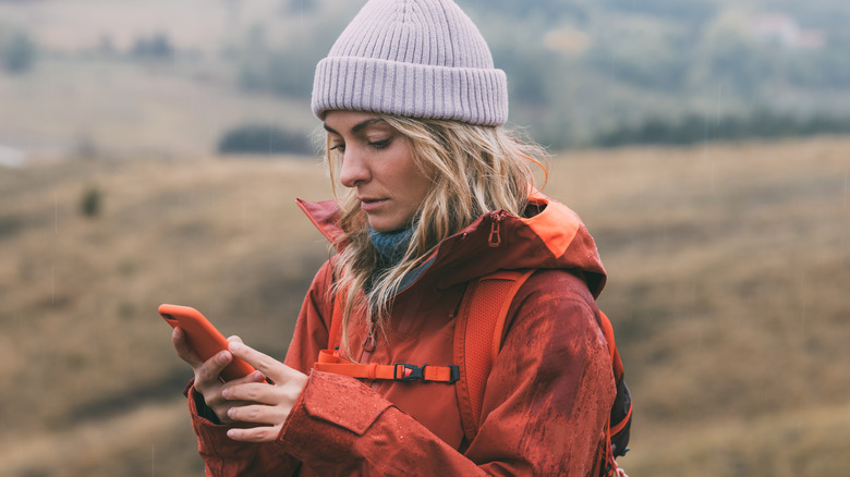 person using iPhone on hike