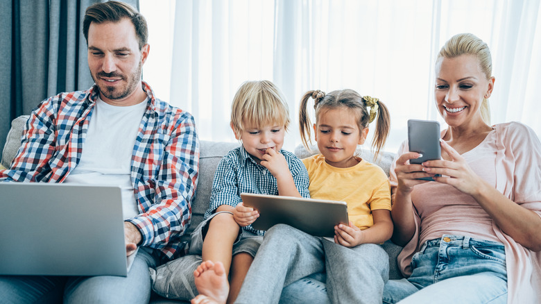 family using laptop, tablet, and smartphone