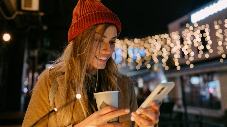 Girl on phone holding cup