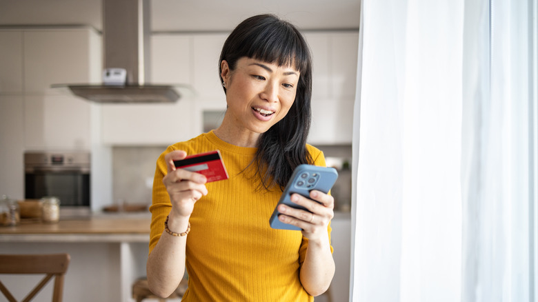 woman holding iPhone and credit card