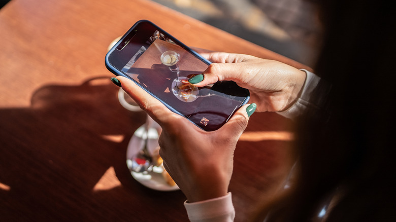 Woman taking picture of food with phone