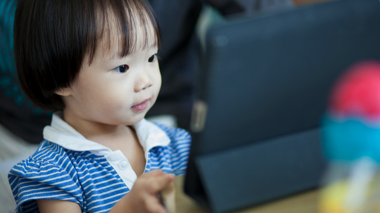 child looking at iPad screen