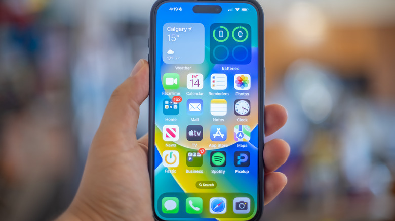 A hand holding an iPhone 15 Plus.