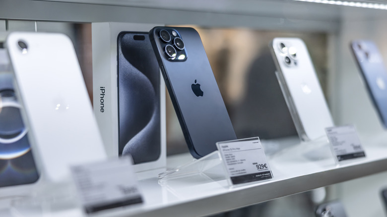 A line of iPhones in a display case.