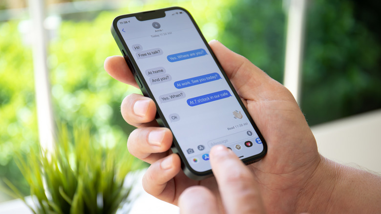An iPhone in hand using the Messages app