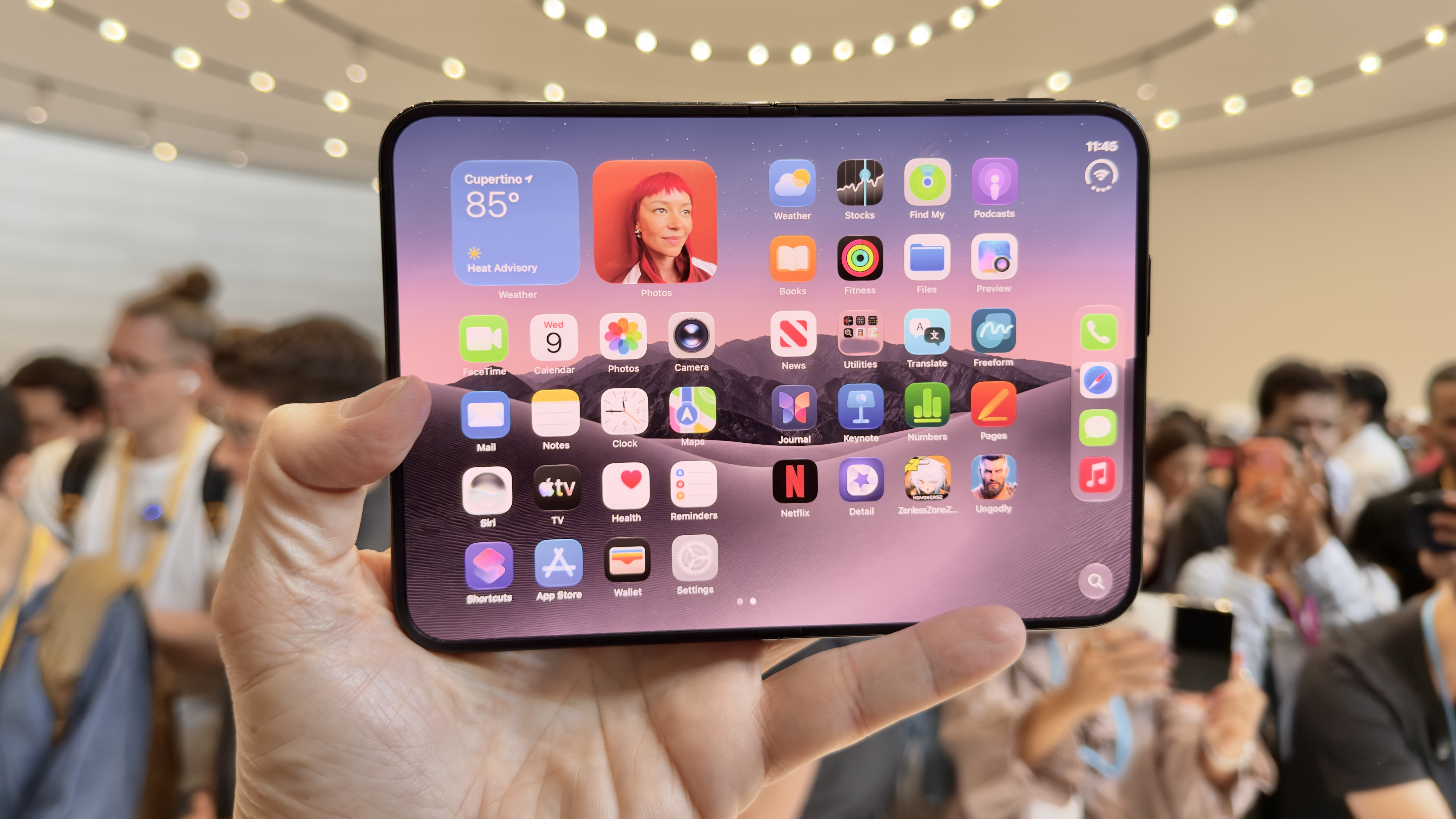 A hand holding the iPhone Duo with the screen open