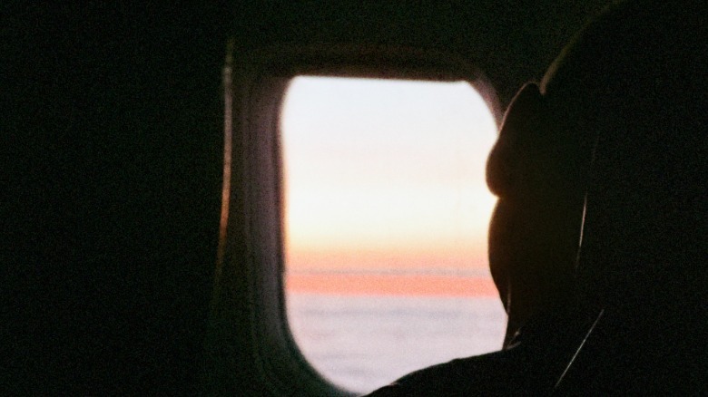 Textured grain photo of a silhouette next to a plane window